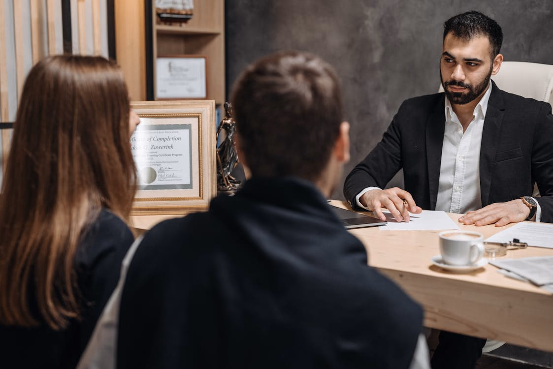 A professional family lawyer at a desk reviewing documents, with bookshelves visible in the background - a reassuring and approachable consultation setting