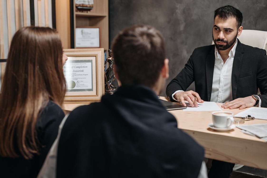A professional family lawyer at a desk reviewing documents, with bookshelves visible in the background - a reassuring and approachable consultation setting