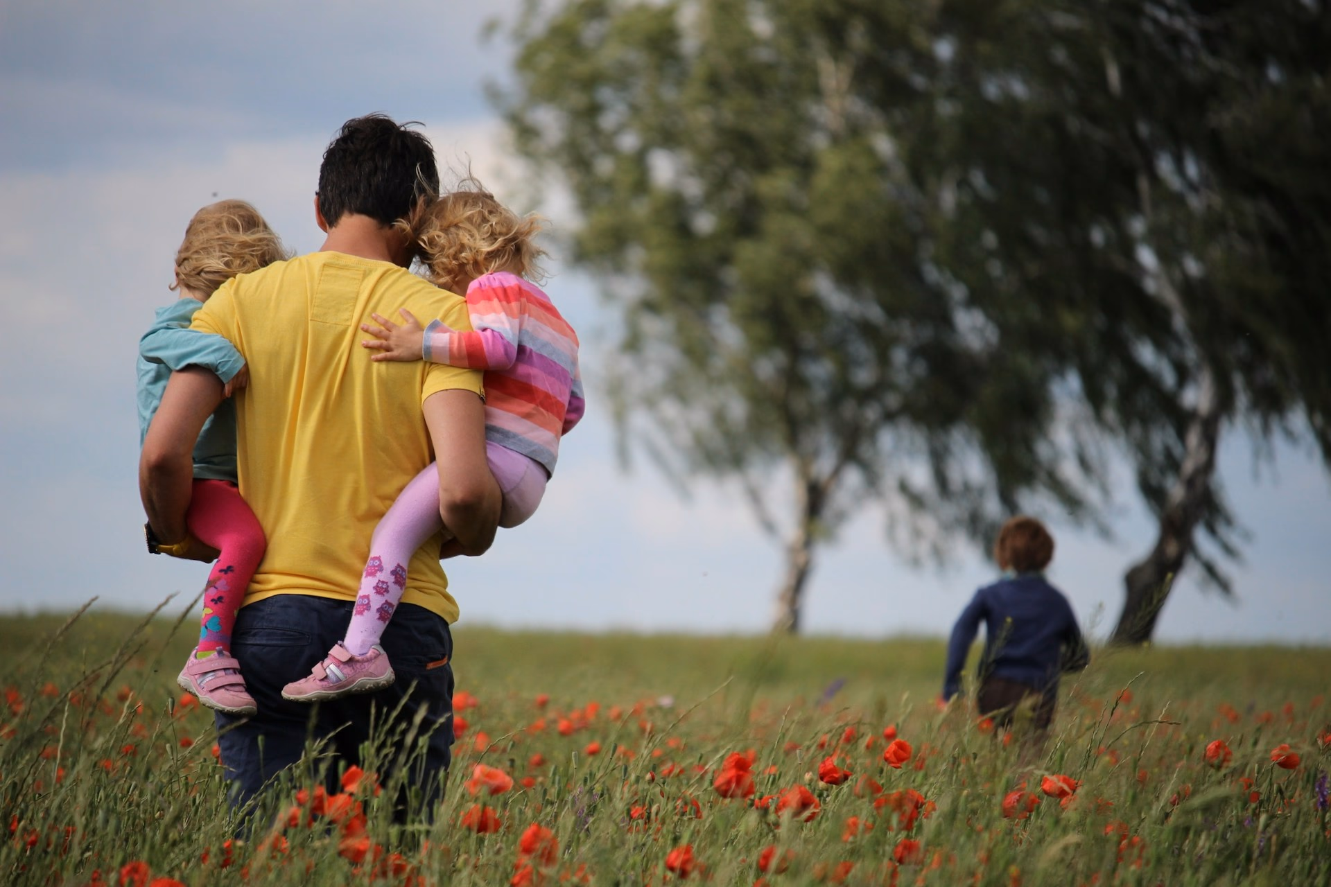 Parent walking in field with children