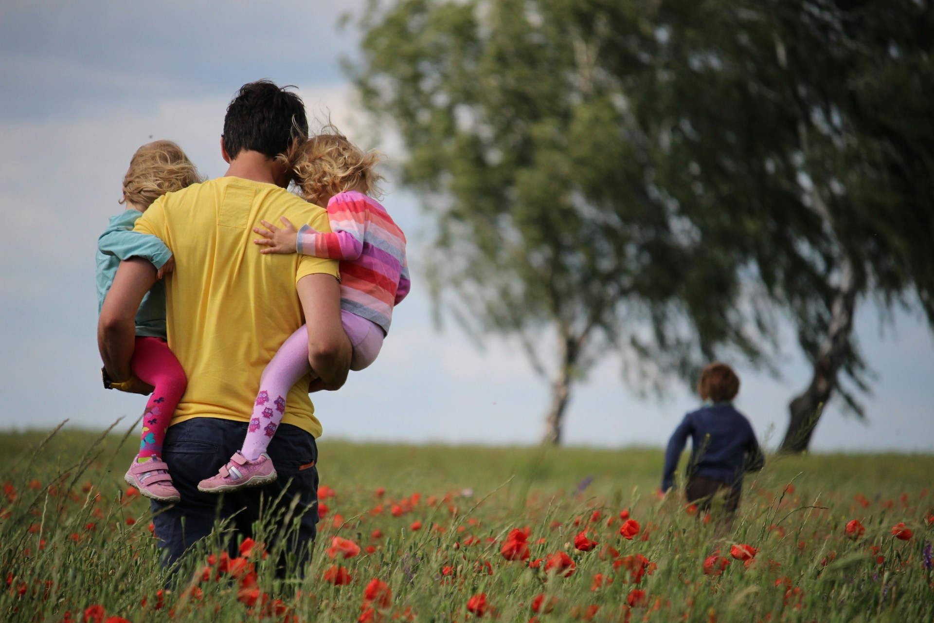 Parent walking in field with children
